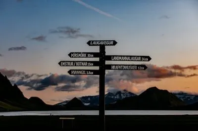 Wegwijzer van de Laugavegur bij Álftavatn in de schemering, met richtingen naar Þórsmörk, Emstrur, Hvanngil, Landmannalaugar en Hrafntinnusker